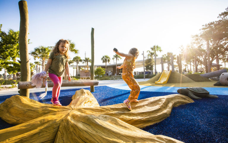 girls running on starfish sculpture St. Pete playground